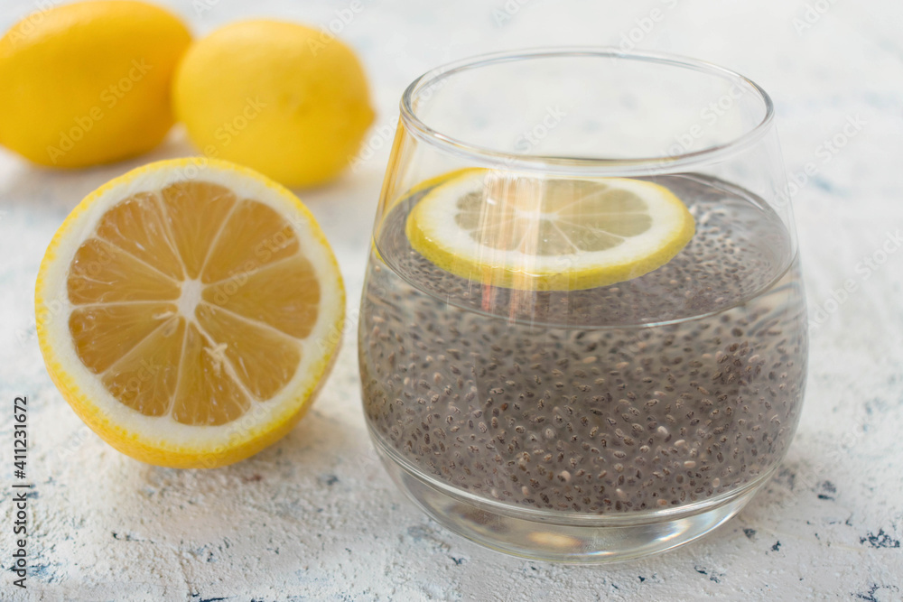 Glass of water with chia seeds and lemon on a white background. Large palan. Glass of water with chia seeds and lemon on a white background. Large palan.
