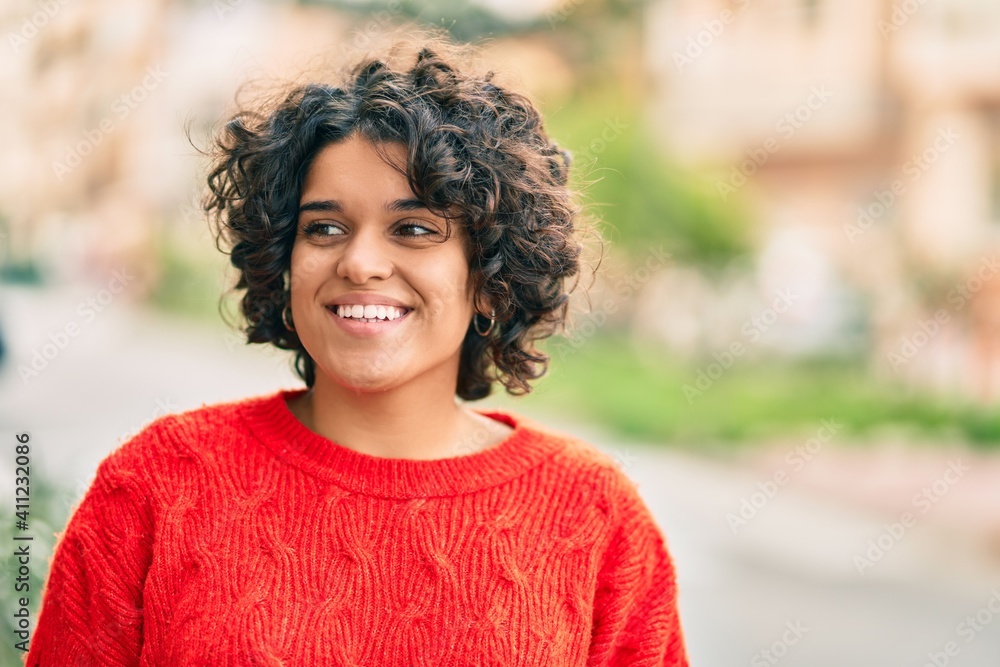Young hispanic woman smiling happy looking to the side at the city. Young hispanic woman smiling happy looking to the side at the city.