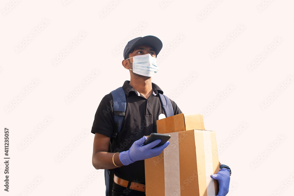Indian delivery man holding Cardboard Box with something in mobile phone Indian delivery man holding Cardboard Box with something in mobile phone