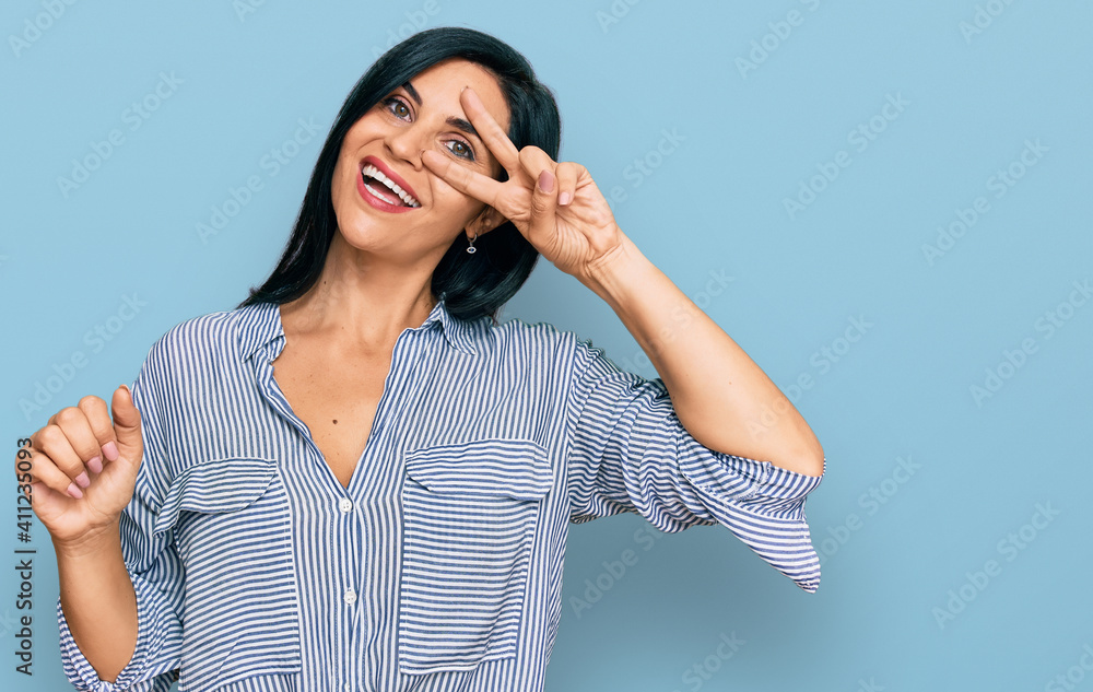 Young caucasian woman wearing casual clothes doing peace symbol with fingers over face, smiling cheerful showing victory Young caucasian woman wearing casual clothes doing peace symbol with fingers over face, smiling cheerful showing victory