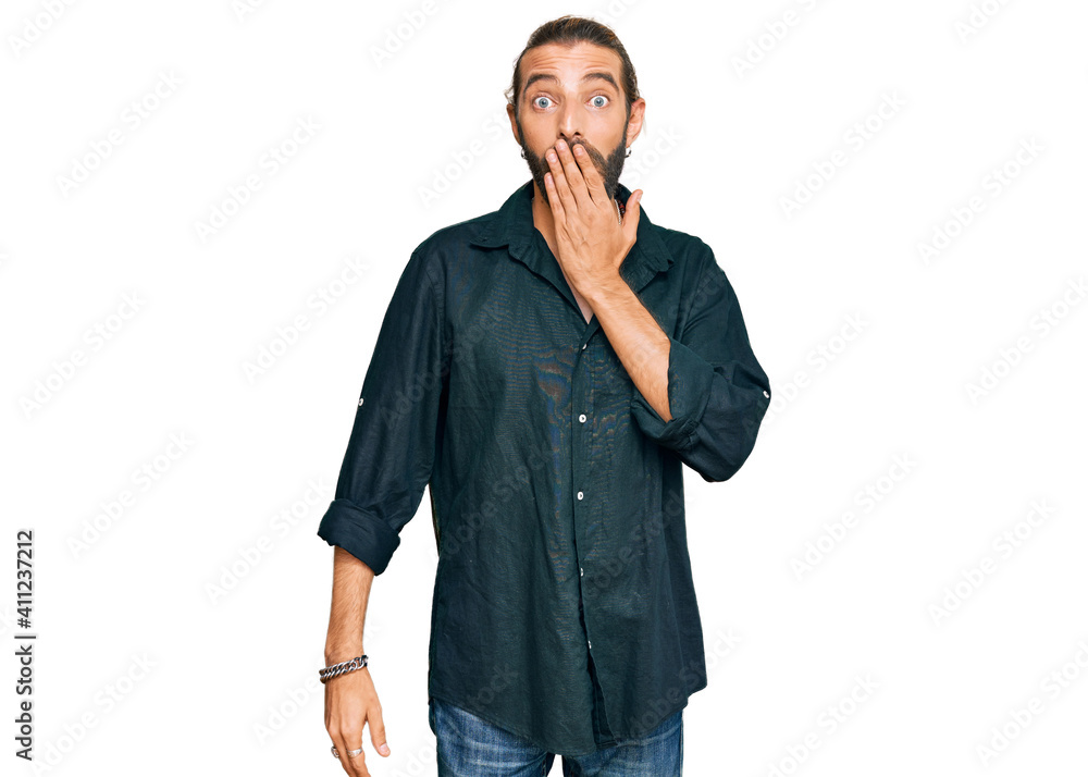 Attractive man with long hair and beard wearing casual clothes covering mouth with hand, shocked and afraid for mistake. surprised expression Attractive man with long hair and beard wearing casual clothes covering mouth with hand, shocked and afraid for mistake. surprised expression