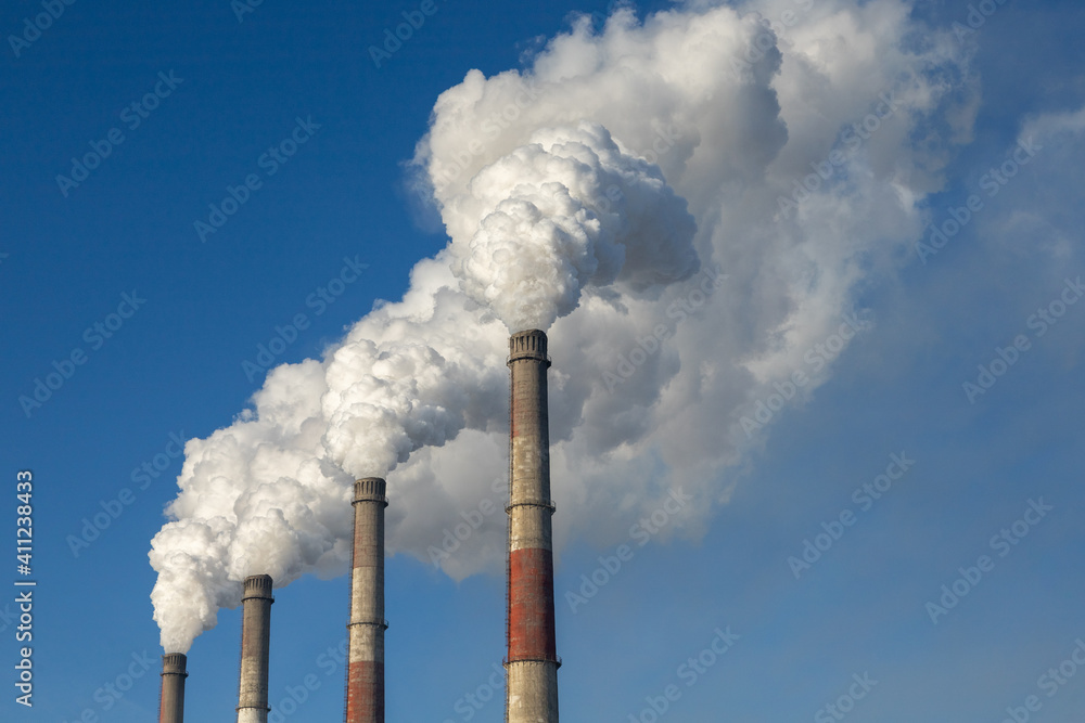 The pipes of thermal power plants spew smoke into the air. The concept of pollution and global warming.