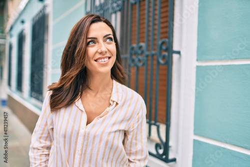 Young hispanic woman smiling happy walking at the city. Free Download Young hispanic woman smiling happy walking at the city. - GFXLoad