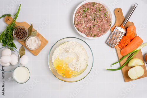 the process of cooking Uzbek manti at home, the ingredients are meat, vegetables, dough. top view on a light background