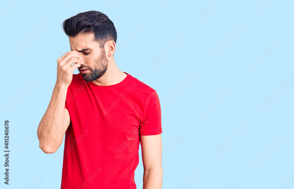 Young handsome man with beard wearing casual t-shirt tired rubbing nose and eyes feeling fatigue and headache. stress and frustration concept. Young handsome man with beard wearing casual t-shirt tired rubbing nose and eyes feeling fatigue and headache. stress and frustration concept.