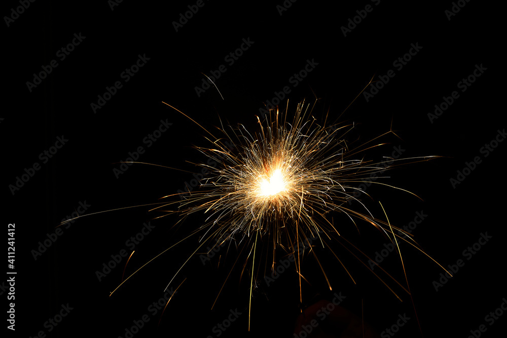 New year sparkler in hands on black background