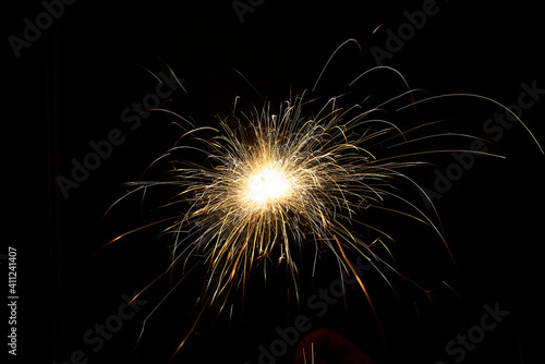 New year sparkler in hands on black background