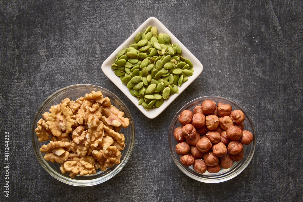 Nuts and pumpkin seeds close-up on gray background, healthy lifestyle