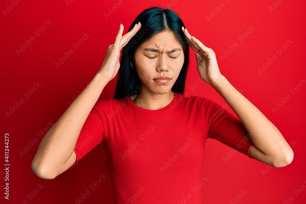Young chinese woman wearing casual clothes with hand on head, headache because stress. suffering migraine. Young chinese woman wearing casual clothes with hand on head, headache because stress. suffering migraine.