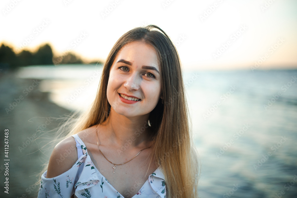 Blonde girl in summer light dress in summer outdoors