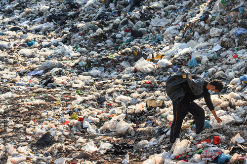 Poor people collect garbage for sale People living in garbage heaps walking to collect recyclable waste to be sold to poverty concept world environment day photo