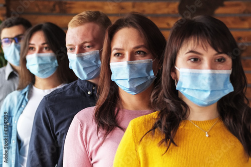 Crowd of young people wearing masks on their faces during the coronavirus pandemic - New normal masked millennials - New concept of normal life.