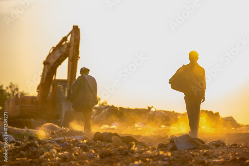 Poor people collect garbage for sale People living in garbage heaps walking to collect recyclable waste to be sold to poverty concept world environment day photo