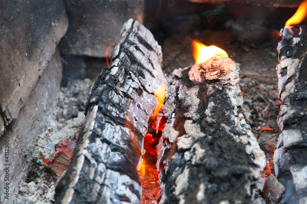 Glowing embers in hot red color, abstract background. The hot embers of burning wood log fire. Firewood burning on grill. Texture fire bonfire embers. Glowing embers in hot red color, abstract background. The hot embers of burning wood log fire. Firewood burning on grill. Texture fire bonfire embers.