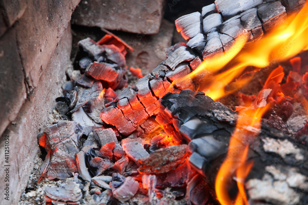 Glowing embers in hot red color, abstract background. The hot embers of burning wood log fire. Firewood burning on grill. Texture fire bonfire embers. Glowing embers in hot red color, abstract background. The hot embers of burning wood log fire. Firewood burning on grill. Texture fire bonfire embers.