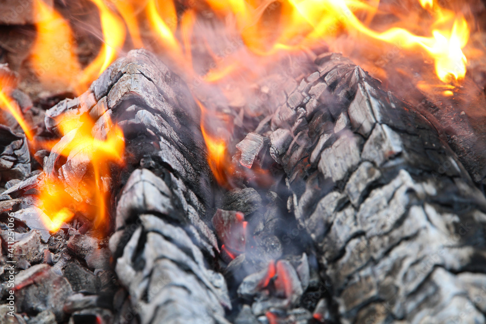 Glowing embers in hot red color, abstract background. The hot embers of burning wood log fire. Firewood burning on grill. Texture fire bonfire embers. Glowing embers in hot red color, abstract background. The hot embers of burning wood log fire. Firewood burning on grill. Texture fire bonfire embers.