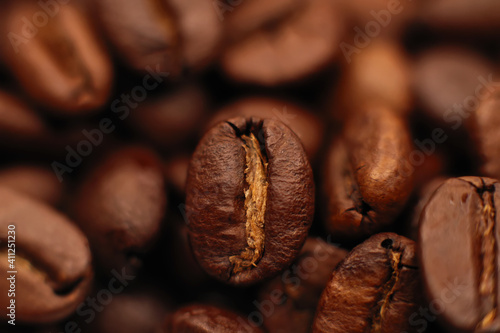 Brown roasted coffee beans, seeds on a dark background. Espresso dark, aroma, black caffeine drink. Close up of isolated energy mocha, cappuccino ingredient.