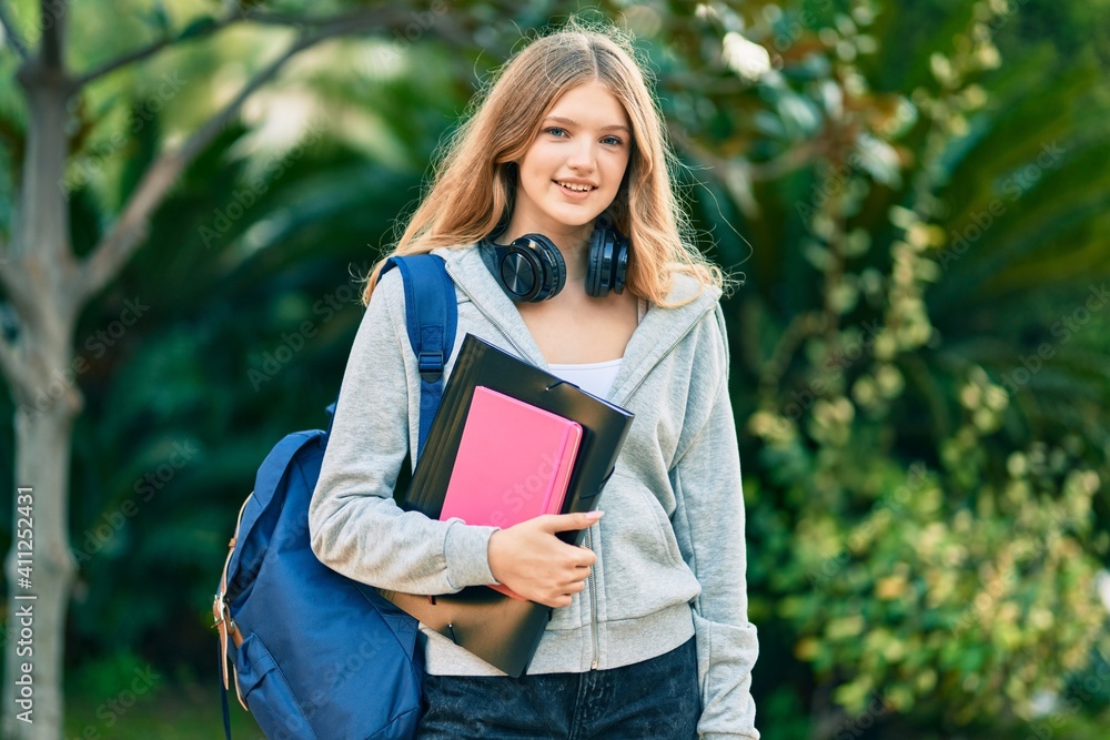 Fototapeta premium Beautiful caucasian student teenager smiling happy using headphones at the park.