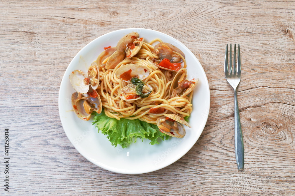 spicy stir fried spaghetti calms with pepper and basil leaf on plate spicy stir fried spaghetti calms with pepper and basil leaf on plate