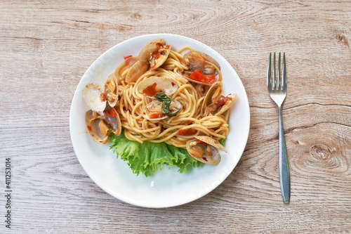 spicy stir fried spaghetti calms with pepper and basil leaf on plate