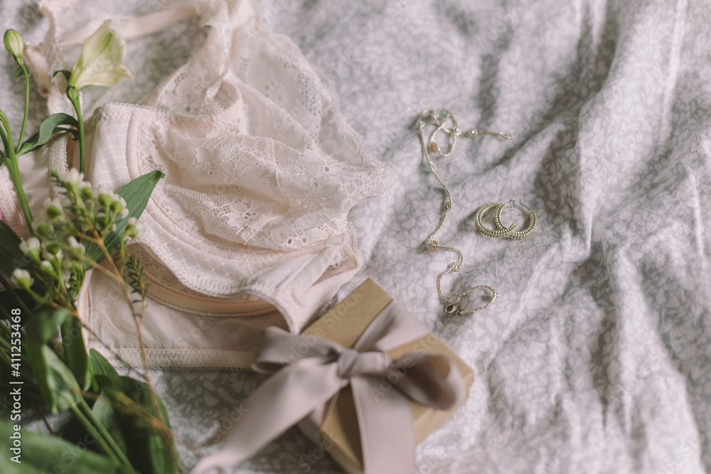 Happy Women's day. Stylish lingerie, gift, jewelry and spring bouquet on bed. Soft trendy image Happy Women's day. Stylish lingerie, gift, jewelry and spring bouquet on bed. Soft trendy image