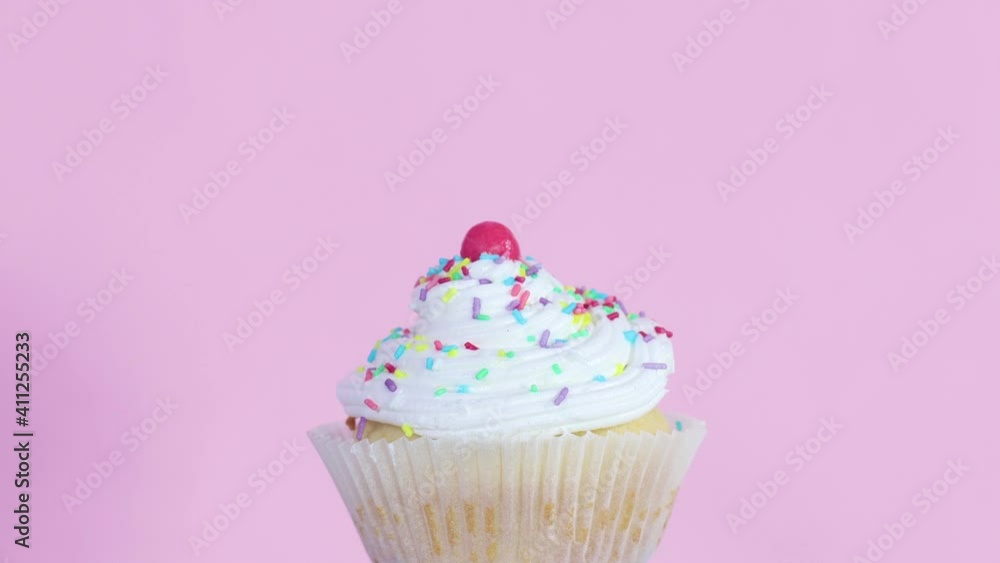 Slowly rotating one cup cake with cream on pink theme Slowly rotating one cup cake with cream on pink theme