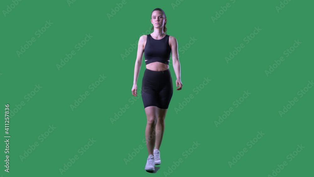 Fit active motivated woman walking and adjusting ponytail hairstyle get ready. Full body on chroma key green screen. Fit active motivated woman walking and adjusting ponytail hairstyle get ready. Full body on chroma key green screen.