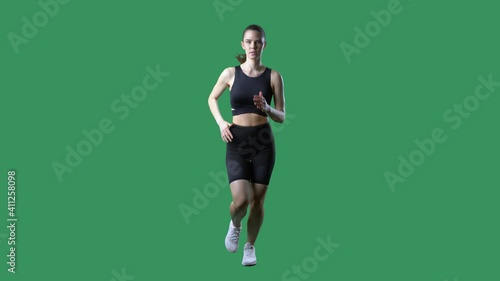 Slow motion of young sporty woman running on treadmill. Full body on chroma key green screen.