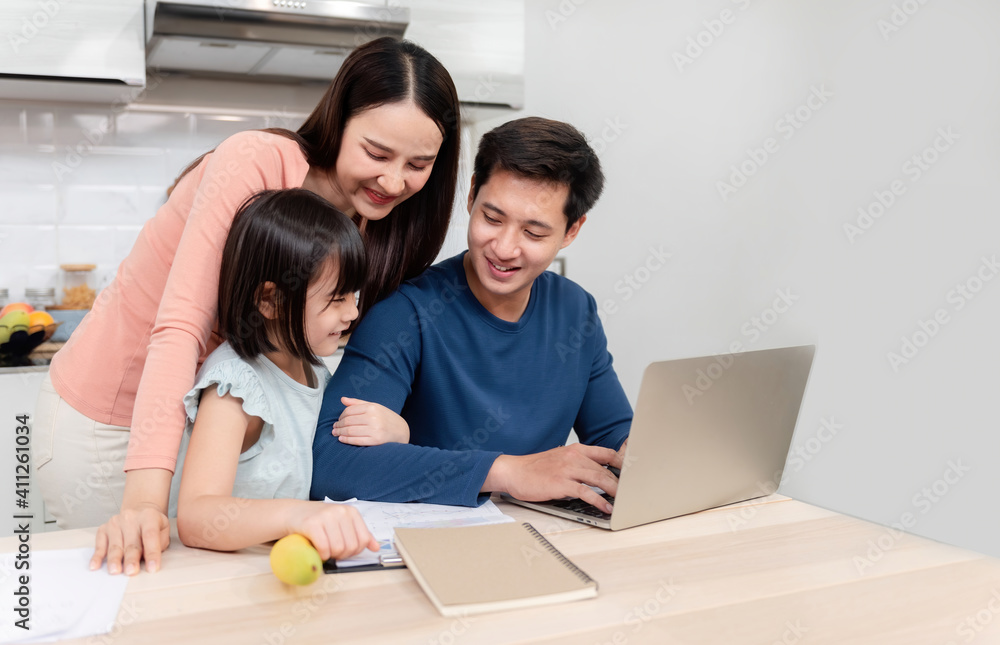 Beautiful asian women Lovely girl Looking at the laptop screen Of handsome men working online on the desk at home It's a new normal life for the family. Beautiful asian women Lovely girl Looking at the laptop screen Of handsome men working online on the desk at home It's a new normal life for the family.