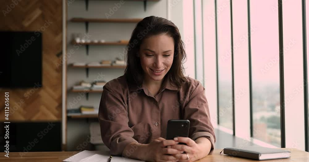 Smiling young beautiful business lady making hello gesture, starting mobile phone video call conversation with colleagues discussing working issues. Happy woman recording stories in social network. Smiling young beautiful business lady making hello gesture, starting mobile phone video call conversation with colleagues discussing working issues. Happy woman recording stories in social network.