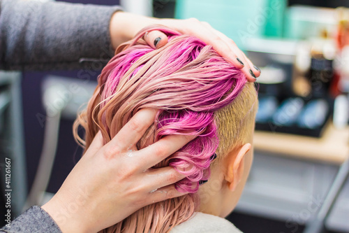Hair dyeing for a girl in a beauty salon, long hair pink.