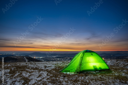Tent on the background of the sunrise in winter in the mountains