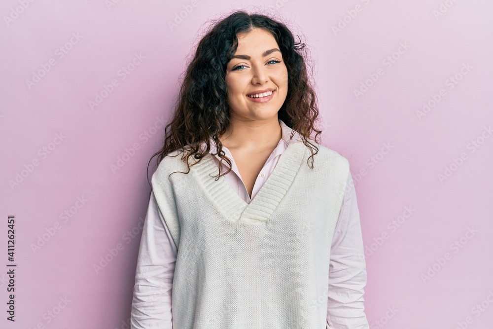 Fototapeta premium Young brunette woman with curly hair wearing casual clothes with a happy and cool smile on face. lucky person.