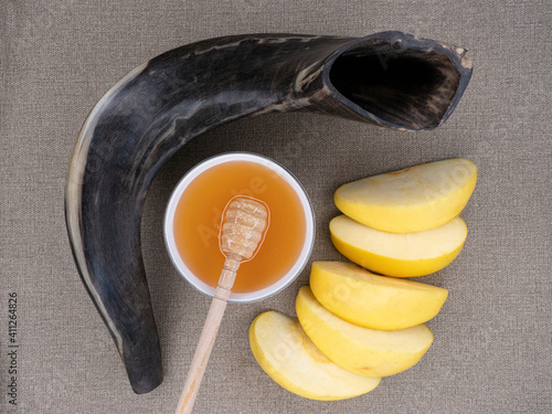 Fotografia Shofar, sliced ​​apple and honey on a canvas background - symbols of the Jewish