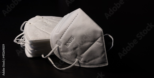 Face surgical white mask FFP2 KN95 N95 disposable for adults on black background. Masks are used to fight and prevent Coronavirus Covid-19 disease
