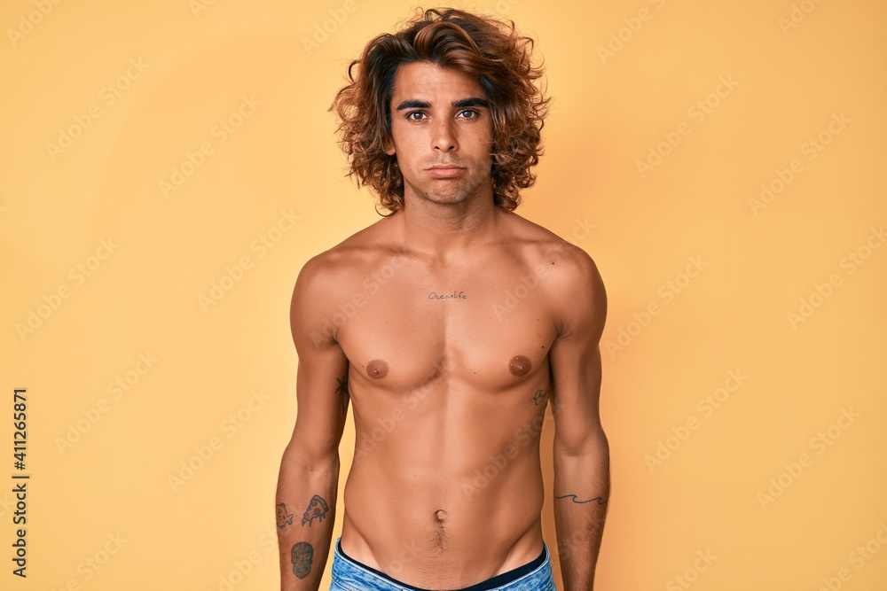Fototapeta premium Young hispanic man standing shirtless depressed and worry for distress, crying angry and afraid. sad expression.