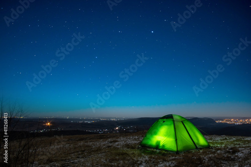 Night at the top of the mountain in a tent in winter against the background of the starry sky © onyx124