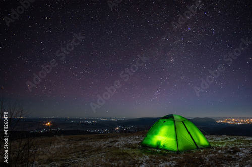 Night at the top of the mountain in a tent in winter against the background of the starry sky © onyx124