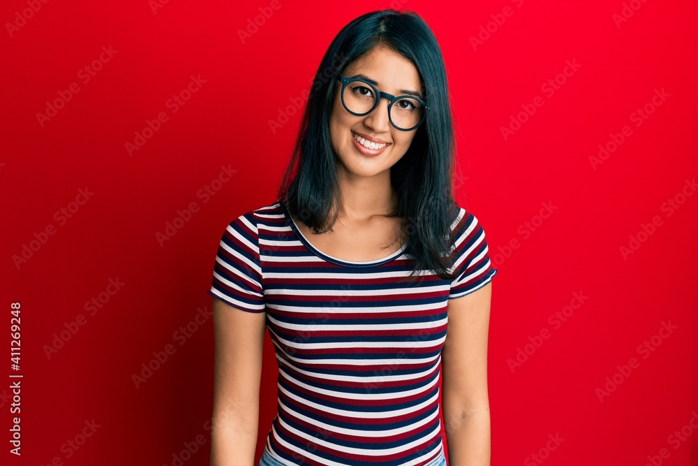 Beautiful asian young woman wearing casual clothes and glasses with a happy and cool smile on face. lucky person. Beautiful asian young woman wearing casual clothes and glasses with a happy and cool smile on face. lucky person.