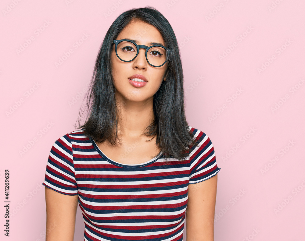 Beautiful asian young woman wearing casual clothes and glasses relaxed with serious expression on face. simple and natural looking at the camera.