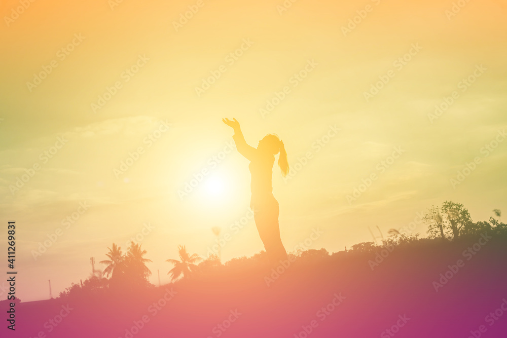 Silhouette of woman praying over beautiful sky background Silhouette of woman praying over beautiful sky background