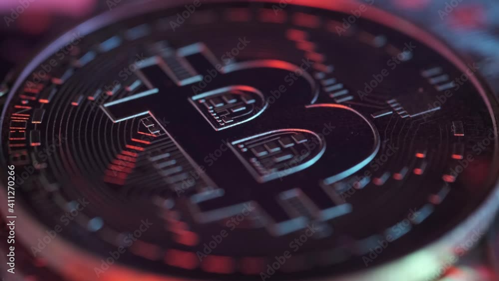 Single Crypto Currency Bitcoin Rotating Under Colorful Lights. Block Chain Technology. New Era of Digital Banking, Finance and E-Commerce.