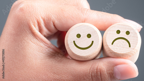 Foto Happy and Unhappy Face on Wood Blocks, Good and Bad Feedback Concept
