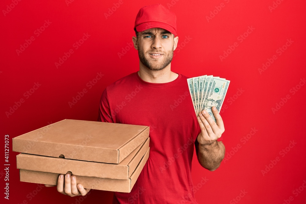 Young caucasian man holding take away food and 20 dollars clueless and confused expression. doubt concept. Young caucasian man holding take away food and 20 dollars clueless and confused expression. doubt concept.