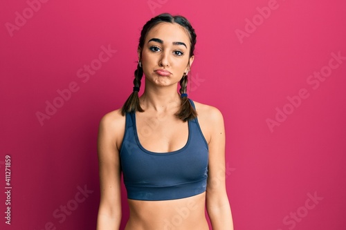 Young brunette girl wearing sportswear and braids depressed and worry for distress, crying angry and afraid. sad expression. © Krakenimages.com