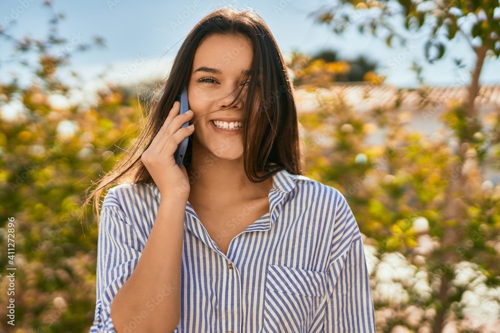 Young hispanic girl smiling happy talking on the smartphone at the city. Young hispanic girl smiling happy talking on the smartphone at the city.