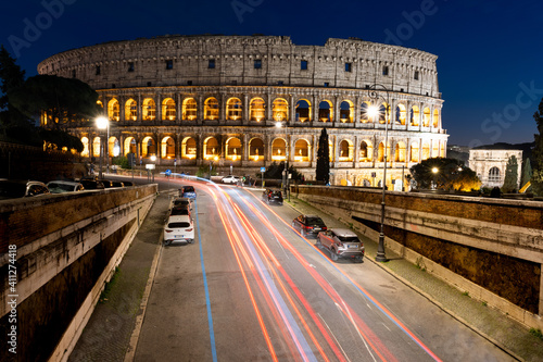 lunga esposizione notturna del colosseo, con scie di luce delle auto 