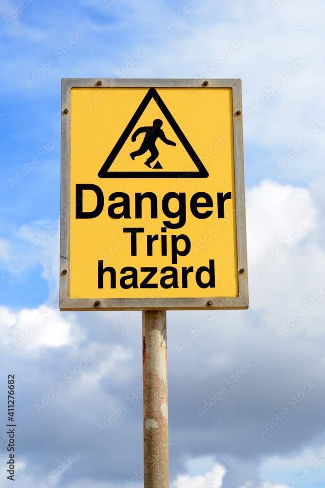 Danger trip hazard yellow sign with blue sky background