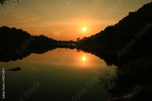 Symmetrical sunset reflected in lake, Indai photo