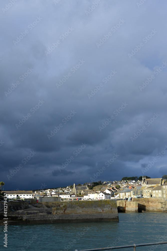 Dark clouds behind Sunny Porthleven Cornwall 